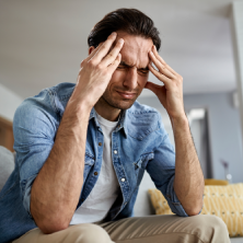 Hombre estresado, sujetándose la cabeza por problemas emocionales.