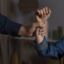 Mano agarrando con fuerza la muñeca de otra mano, como símbolo de problemas emocionales.