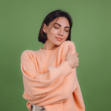 Chica abrazándose, mostrando felicidad y la superación de problemas emocionales.